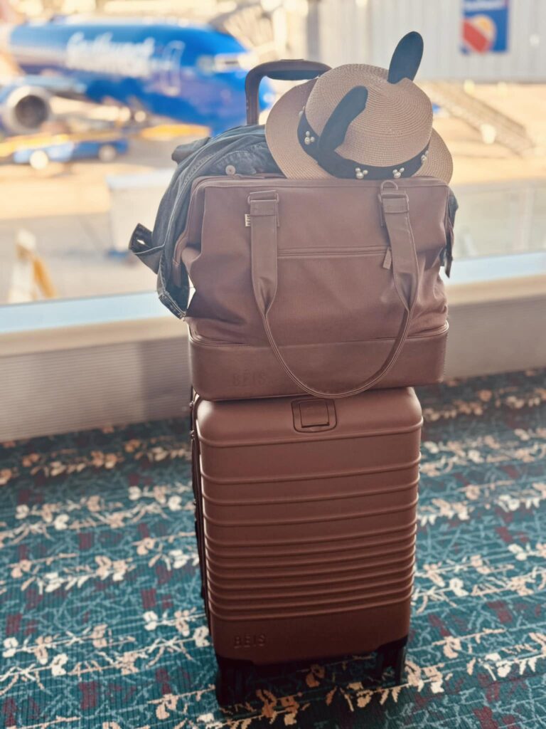 Beis weekender tote stacked on top of Beis carryon bag at luggage carousel