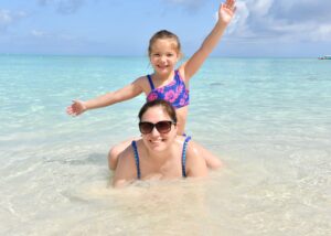 mother and daughter at the beach in blue water